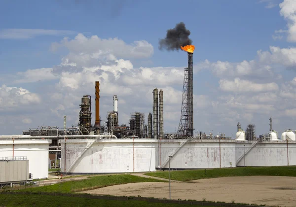 Silos y chimenea con fuego y humo en una refinería de petróleo — Foto de Stock