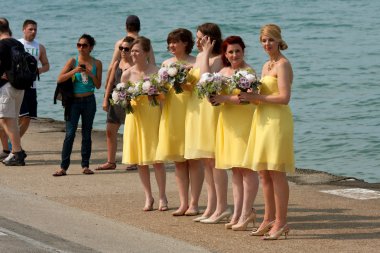 Bridesmaids Prepare For Photo Standing By Lake Michigan clipart