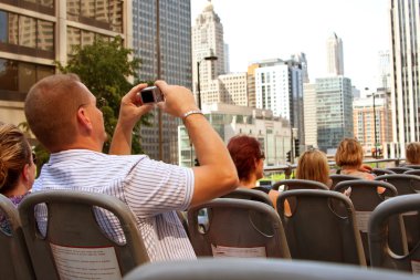 Tourist Snaps Photos Of Chicago Skyline From Sightseeing Bus clipart