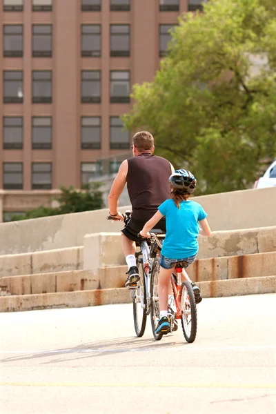 stock image Man And Child Ride Tandem Bike In City