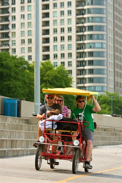 Turisté pedál čtyř kolových cyklu podél asfaltové chicago — Stock fotografie