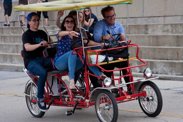 Los adultos jóvenes pedalean un ciclo de cuatro ruedas a lo largo de Lakeshore Drive — Foto de Stock