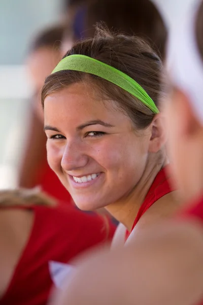 Kvinne-softballspiller Flashild-smil fra Dugout – stockfoto