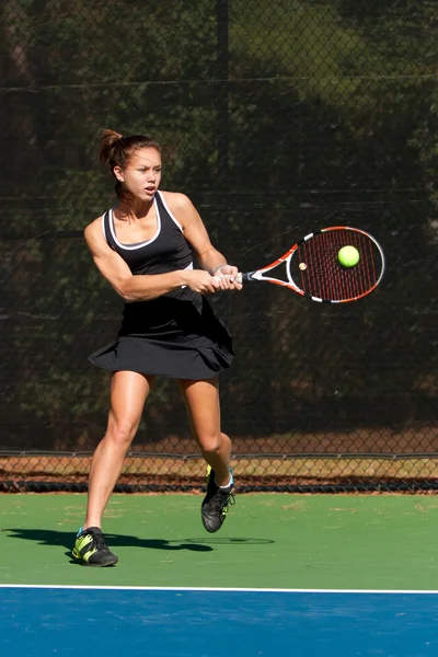 Giocatrice di tennis femminile colpisce potente colpo al rovescio — Foto Stock