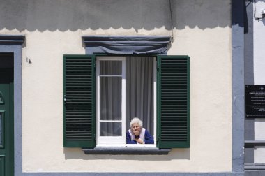 yaşlı kadın pencereden dışarı bakarak