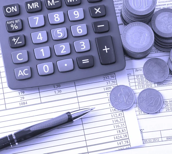 Coin, a calculator, a pen on the business papers — Stock Photo, Image