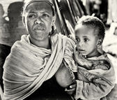 Egy azonosítatlan etióp nő gyermekét tartja a kezét