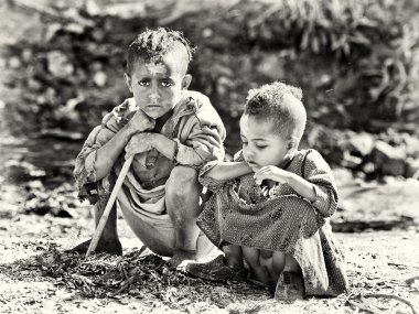 Two Ethiopian children sit on the ground clipart