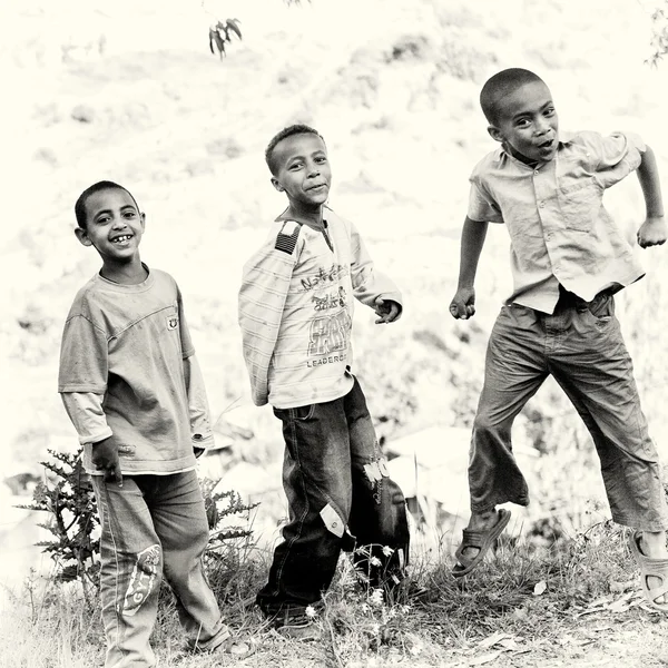 De sprong van de Ethiopische jongens lachend voor de camera — Stockfoto