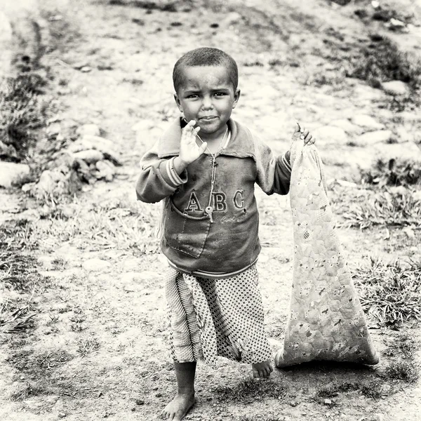 エチオピアの少年彼の首に彼の手およびチャンピオンの袋を運ぶ — ストック写真