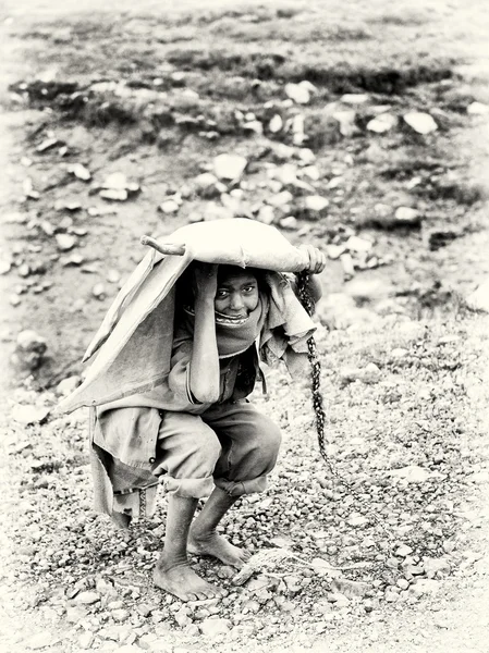 Um rapaz etíope tenta esconder-se debaixo da roupa — Fotografia de Stock