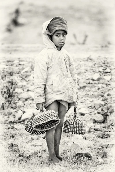 An Ethiopian girl carries hats in her hands — Stock Photo, Image