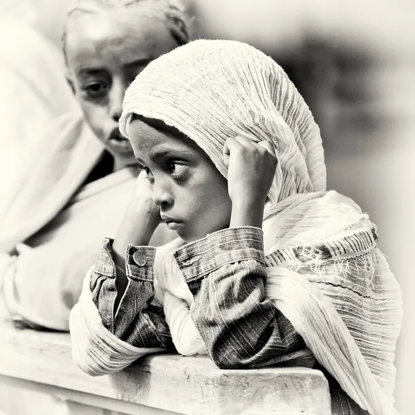 Uma menina etíope observa muito atentamente e fecha os ouvidos — Fotografia de Stock