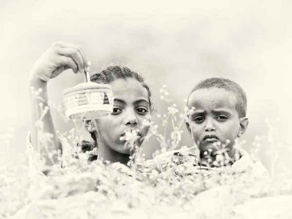 Etiopské chlapec a dívka prodává ptáky v kleci — Stock fotografie