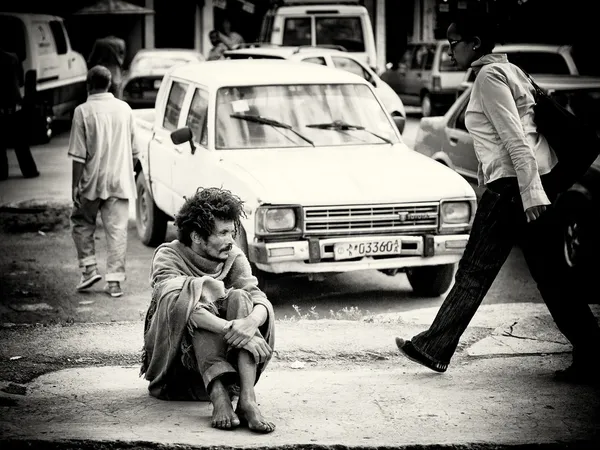 На дороге сидит эфиопский бездомный. — стоковое фото