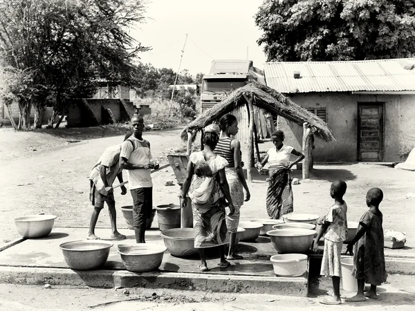 En grupp av benin nära den väl väntar på tur att få vatten — Stockfoto