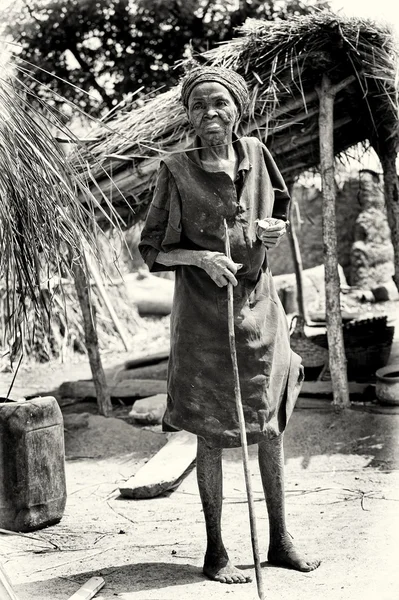 Een oude dame uit benin loopt met een stok — Stockfoto