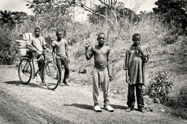 Un grupo de niños Benin caminando en el campo y montando en bicicleta —  Fotos de Stock