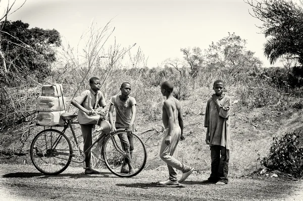 Quattro bambini del Benin parlano vicino alla bicicletta — Foto Stock