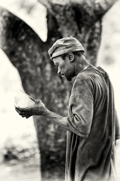 Een benin man met een schotel in zijn hand — Stockfoto