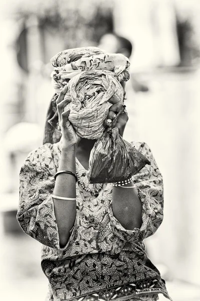 A Benin young girl in a very beautiful clothes shuts her face with tissue — Stock Photo, Image