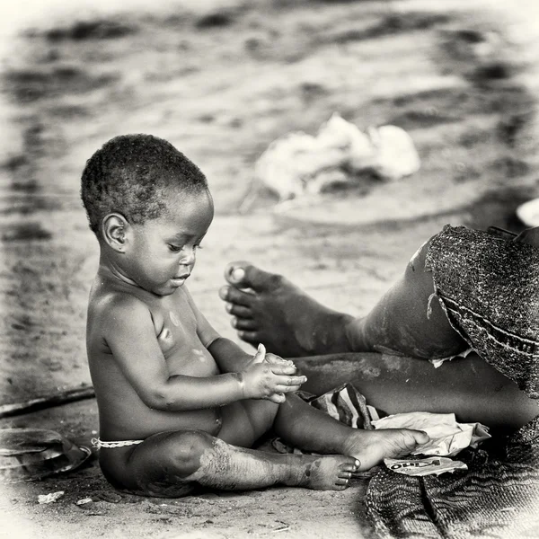 Pequena menina Benin brinca no chão — Fotografia de Stock
