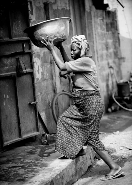 Benin women carries dish with water — Stock Photo, Image