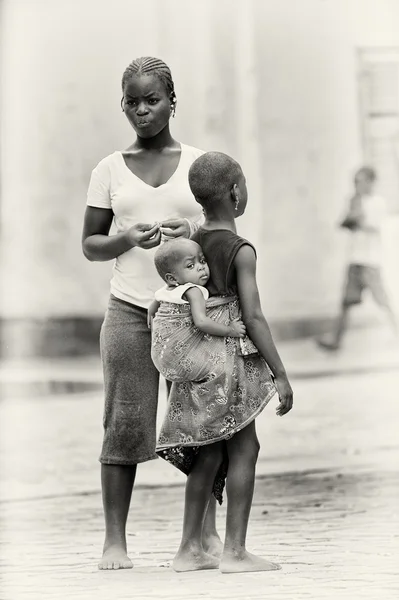 Бенин мать с детьми и один брат несет другой на спине — стоковое фото