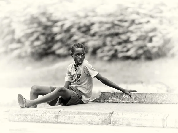 Benin chlapec sedí na zemi — Stock fotografie