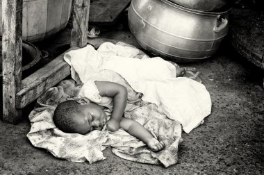 Little Ghanaian baby has to sleep on the ground clipart