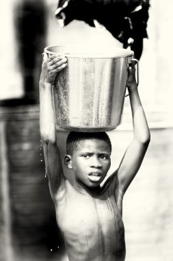 bir leğen su ile genç Ganalı çocuk