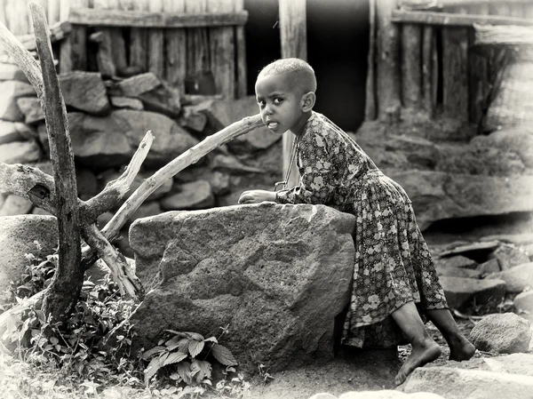 Pequena menina etíope fica ao lado da pedra — Fotografia de Stock
