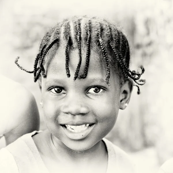 Маленькая ганская девочка позирует перед камерой и улыбается. — стоковое фото