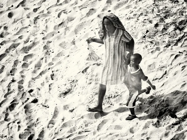 Ghanees moeder en haar zoon lopen over het zand — Stockfoto