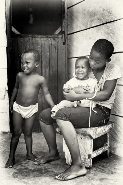 年轻的加纳母亲与她的孩子们和小小的一个哭 — 图库照片