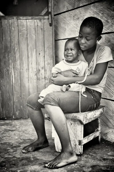 Giovane madre ghanese con un bambino che piange — Foto Stock