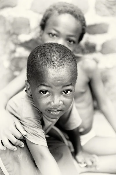 Little Ghanaian boy poses for the camera in front of his sister — Stock Photo, Image