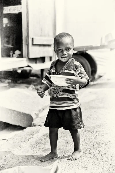 Pequeno menino ganês posa para a câmera com um prato de sopa — Fotografia de Stock