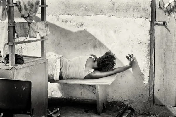 Een Ghanese vrouw slaapt op de Bank van de straat — Stockfoto