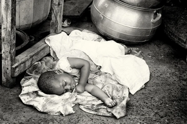 Pequeno bebê ganês tem que dormir no chão — Fotografia de Stock