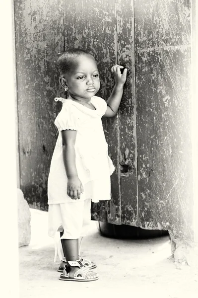Little Ghanaian girl stays near the wall — Stock Photo, Image