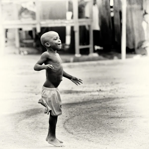 Pequeno menino ganês salta na estrada — Fotografia de Stock