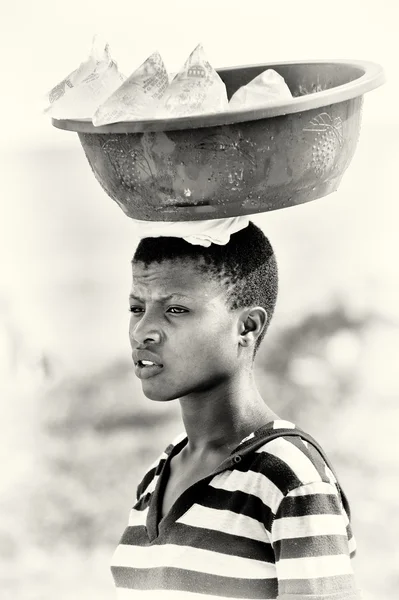 Young Ghanaian woman carries a basin with cold water over her head — Stock Photo, Image