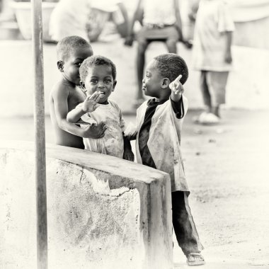 Three Ghanaian children a little shy in front of the camera clipart