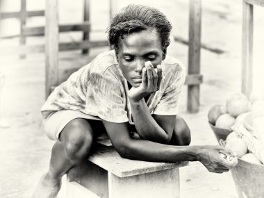 Sad Ghanaian lady sits on a bench and thinks of something clipart