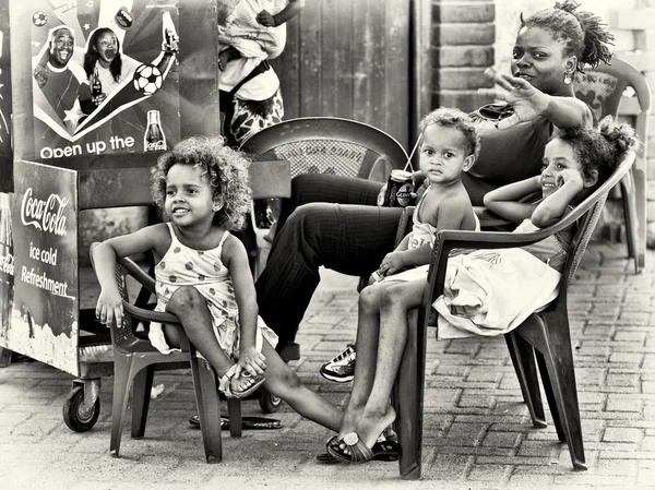 Grupo de niños ghaneses se sienta en las sillas con su madre —  Fotos de Stock