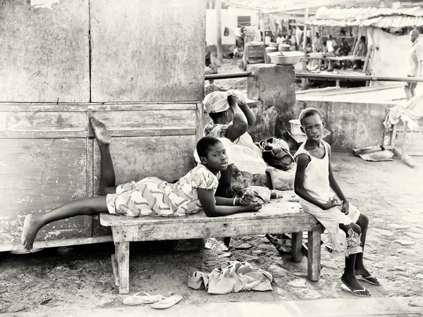 Två Ghanansk pojkar sitter på en bänk nära marknaden — Stockfoto