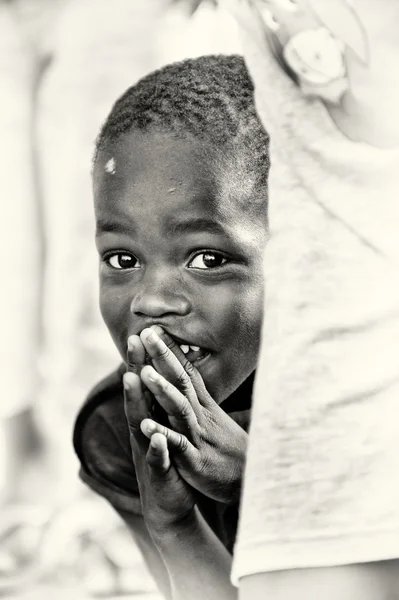 Mały chłopiec ghański chowa się za tkanki — Zdjęcie stockowe