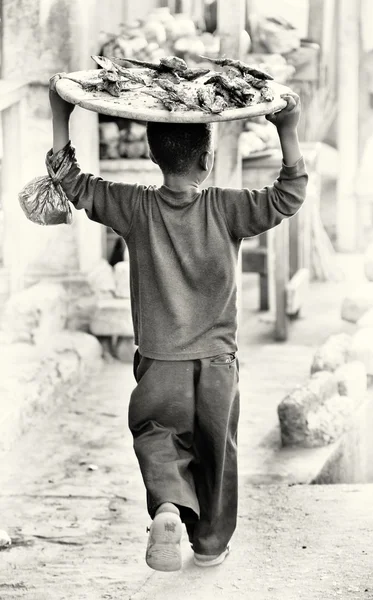 Молодой ганский мальчик с едой на голове — стоковое фото