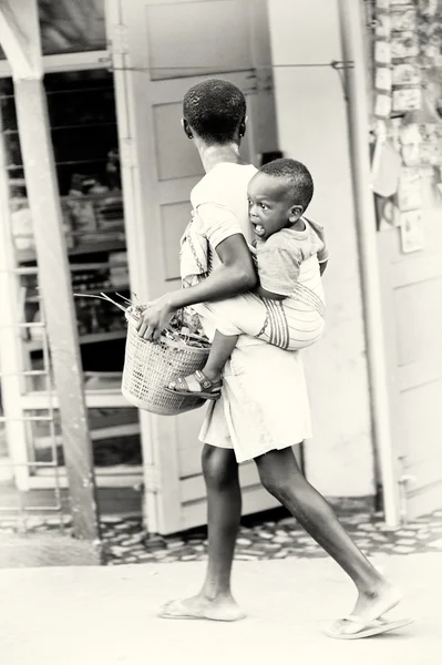 Niñas ghanesas llevan a su hermano en la espalda —  Fotos de Stock